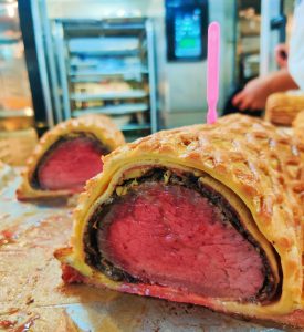 Juicy Beef Wellington with crisp pastry crust, sliced to reveal tender beef inside. Perfect for gourmet food lovers.